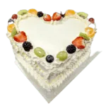 Egg Free heart shaped fresh fruit celebration cake decorated with strawberries, kiwi, grapes, blueberries, blackberries and mandarin segments.