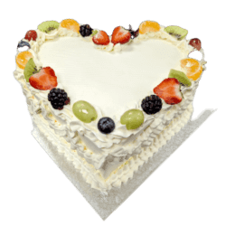 Egg Free heart shaped fresh fruit celebration cake decorated with strawberries, kiwi, grapes, blueberries, blackberries and mandarin segments.