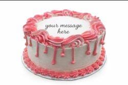 Round white fresh cream birthday cake with pink drip decoration, pink piped borders, textured sides, and a personalised message.