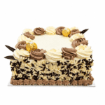 Square Ferrero chocolate celebration cake decorated with chocolate and vanilla whipped frosting rosettes, Ferrero Rocher chocolates, chocolate leaf decorations, and mixed milk and white chocolate curls covering the sides, with a smooth centre for a personalised celebration message.