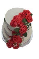 Luxury Egg Free wedding cake featuring three tiers with handcrafted red rose cascade decoration.