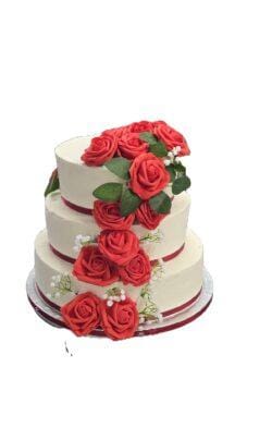 Egg Free three tier wedding cake with cascading red roses, white floral accents and elegant cream finish.