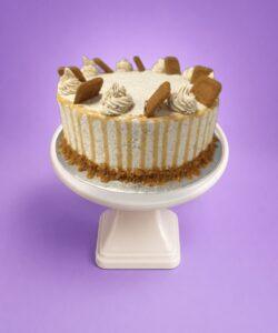 Egg Free Biscoff drip celebration cake decorated with Biscoff biscuits, Biscoff cream swirls, Biscoff crumb coating and Biscoff drip.