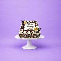 Square fresh cream celebration cake decorated with chocolate and vanilla swirls, white floral piping, Ferrero Rocher chocolates, chocolate leaf decorations, milk and white chocolate shavings, and a personalised message.