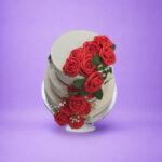 Luxury Egg Free wedding cake featuring three tiers with handcrafted red rose cascade decoration.