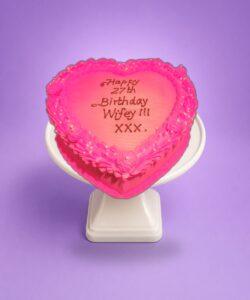 Egg Free Pink Heart Celebration Cake with a vibrant pink cream finish, decorative cream border, edible pearls and a personalised message.