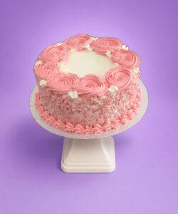 Egg Free pink rosette celebration cake with textured cream sides, pink decorative swirls and space for a personalised message.