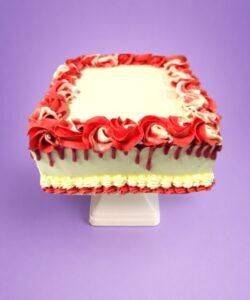 Egg Free square celebration cake with a red drip finish, red and white decorative swirls, and space for a personalised message.