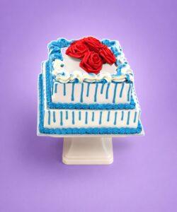 Royal Blue Drip Rose Celebration Cake with fresh cream finish and red roses by Cake Palace