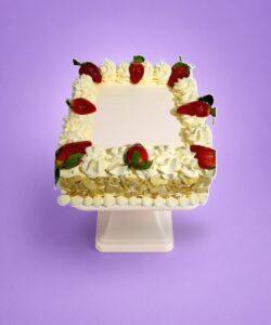 Egg-free strawberry celebration cake decorated with fresh strawberries, smooth vanilla cream, almond flake sides and space for a personalised message.