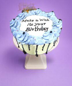 stylish Egg Free Blue Chocolate Drip Birthday Cake decorated with blue piping, chocolate drip, edible pearls and a personalised cake topper. Freshly made to order in Sheffield for birthdays and special celebrations.