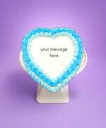 Top view of a blue heart celebration cake featuring elegant blue piped frosting around a white centre ready for a custom birthday message.