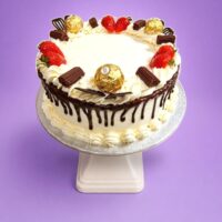 Chocolate drip celebration cake with fresh cream icing, chocolate ganache drip, fresh strawberries, Ferrero Rocher chocolates, chocolate curls, chocolate sticks and chocolate decorations, round birthday cake with space for personalised message, Cake Palace UK.