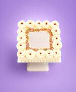 Top view of a square fresh cream celebration cake featuring piped cream rosettes with classic jam dots, a colourful rainbow sprinkles border, a smooth centre for a personalised message, and elegant fresh cream finishing, handmade by Cake Palace UK.