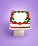 Square Christmas buttercream cake with Santa decorations and smooth white icing.
