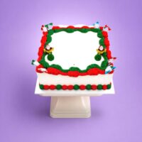 Square Christmas buttercream cake with Santa decorations and smooth white icing.