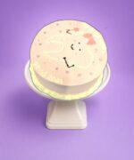 Cute tooth fairy birthday cake with smiling tooth design on pastel pink frosting
