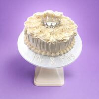 Elegant Ivory Crown Wedding Cake with ivory fresh cream rosettes, silver crown topper, egg-free vanilla or chocolate sponge from Cake Palace.