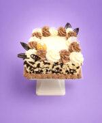 Ferrero Rocher & Chocolate Flake Celebration Cake with vanilla and chocolate buttercream swirls, white and dark chocolate flakes around the sides, Ferrero Rocher chocolates, and elegant dark chocolate decorations. Freshly made by our Sheffield bakery.