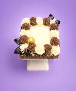 Top view of Ferrero Rocher & Mix Chocolate & White Curls Celebration Cake featuring chocolate and vanilla buttercream swirls, Ferrero Rocher chocolates, dark chocolate decorations, and a smooth centre ready for a personalised message.