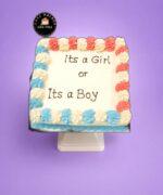 It's a Boy or It's a Girl gender reveal cake with pink and blue decorations