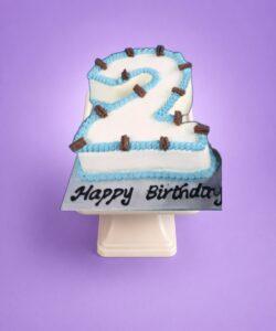 Egg Free number 2 birthday cake with blue piping, chocolate flakes and personalised message, available in any number 0–9 from Cake Palace Sheffield