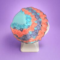 Elegant heart-shaped birthday cake with pastel floral decorations and pearl accent