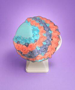 Elegant heart-shaped birthday cake with pastel floral decorations and pearl accent