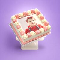 Personalised square birthday cake with a custom edible photo printed on top, finished with pink and white piped swirls around the border, smooth white icing finish, and matching pink piped base trim. Ideal for birthdays, children's parties, anniversaries, baby celebrations, and personalised cake gifts.
