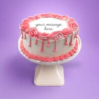 Round white fresh cream birthday cake with pink drip decoration, pink piped borders, textured sides, and a personalised message.