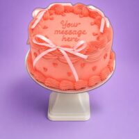 Celebrate life's sweetest moments with our Pink Ribbon Heart Celebration Cake, beautifully designed with a soft pink fresh cream finish and elegant heart-shaped details. Decorated with delicate piped borders, charming ribbon bows, and embossed heart accents, this stylish cake offers a modern yet romantic look. Finished with space for your personalised message, it's the perfect choice for birthdays, anniversaries, Valentine's Day, baby showers, or any special occasion.