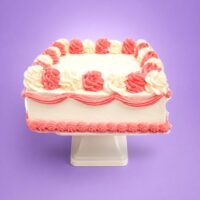 Pink and white square celebration cake with smooth vanilla cream frosting, alternating pink and white buttercream swirls, decorative pink wave piping around the sides, matching pink shell border, and a large blank centre ready for a personalised edible image or custom message.