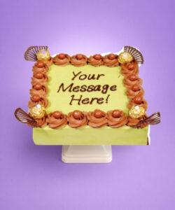 Egg-free pistachio fresh cream cake decorated with Ferrero Rocher chocolates, chocolate curls, chocolate pearls, and personalised message