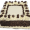 Top view of a square fresh cream cake featuring fresh cream rosettes, chocolate curls, chocolate pearls, chocolate sprinkle border, and space for a personalised message.